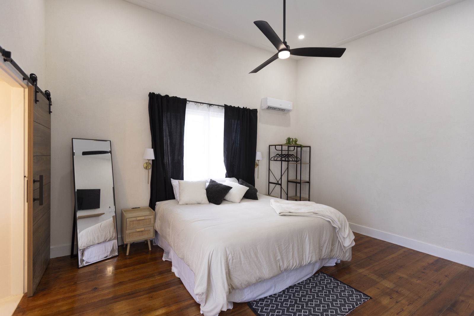 Master bedroom — high ceiling, barn door to ensuite