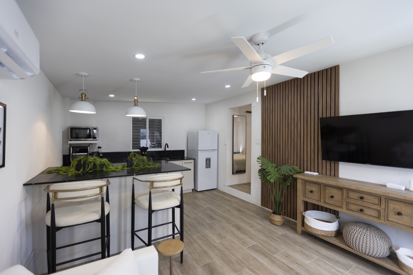 Cottage living area — oak slat feature wall and open-plan kitchen