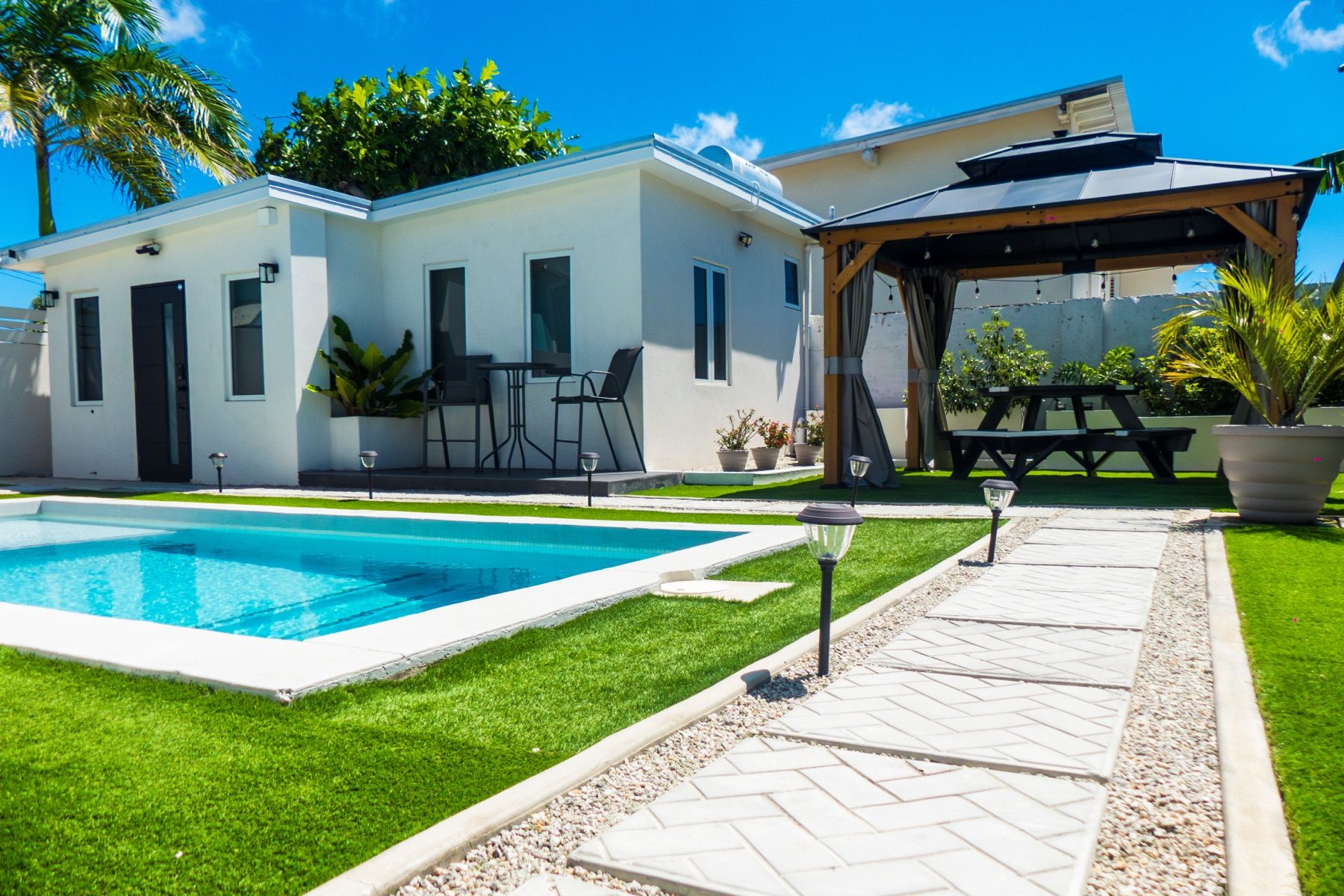 The Cottage — courtyard view with the ONE MAXWELL wordmark wall