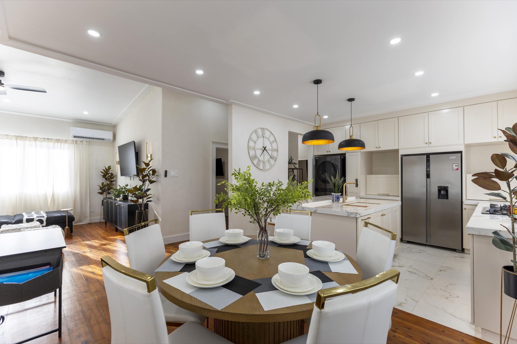 Dining and kitchen open-plan — round table set for six, marble island beyond